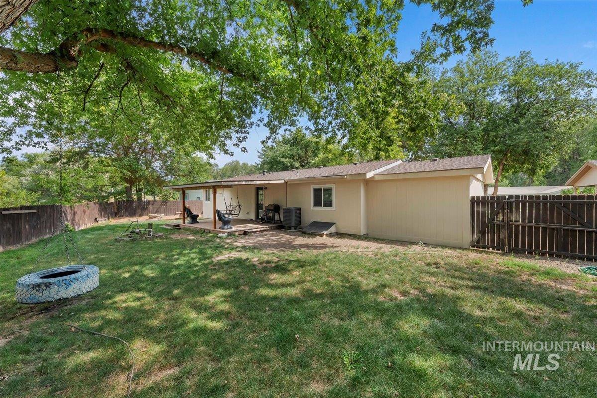 Rear view of property with a fenced backyard, a patio area, and a fire pit