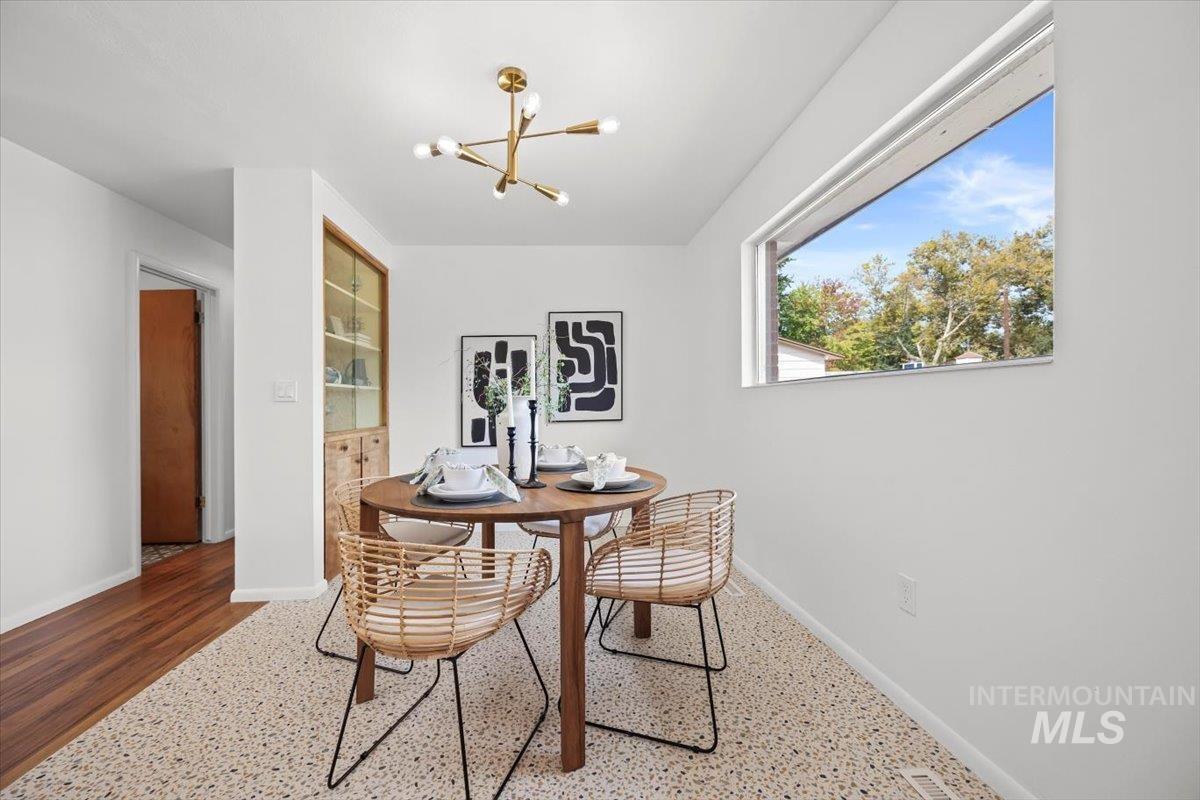 Dining room featuring a chandelier and baseboards
