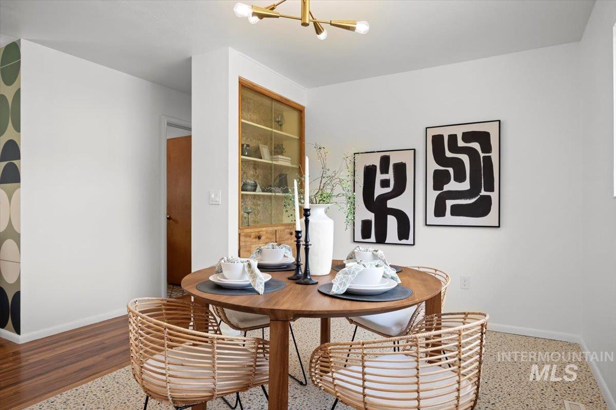 Dining room featuring a chandelier and baseboards