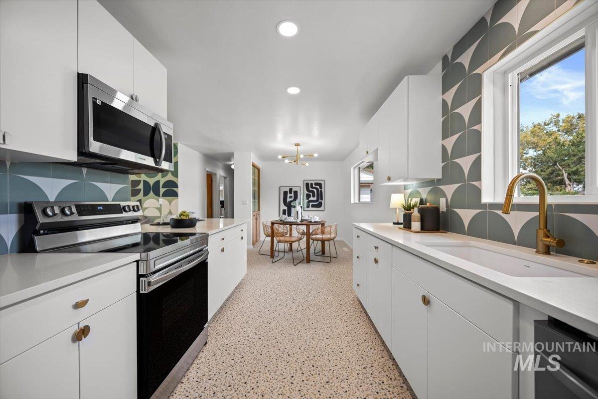 Kitchen with stainless steel appliances, white cabinets, recessed lighting, backsplash, and healthy amount of natural light