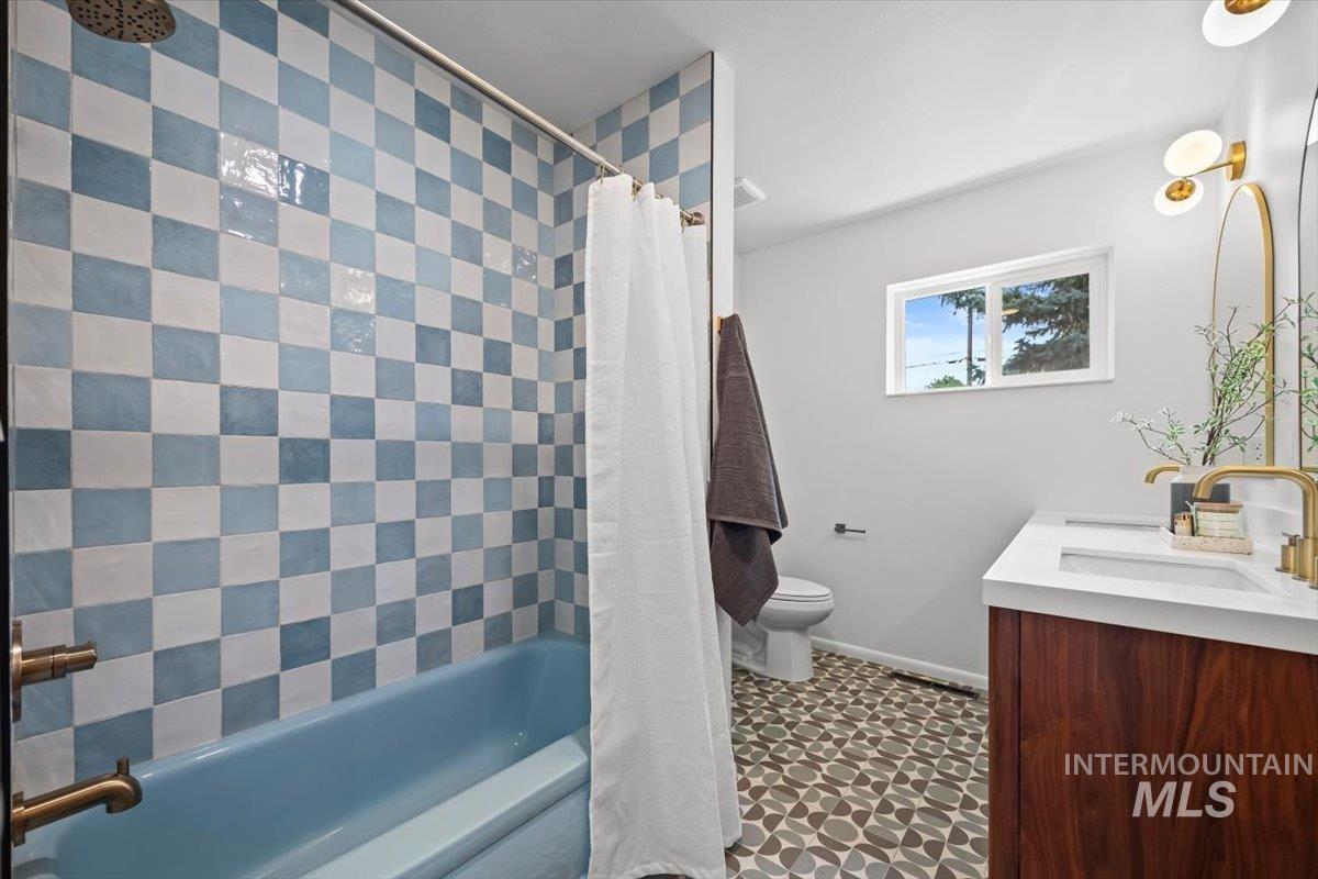 Full bath with shower / bath combo with shower curtain and vanity