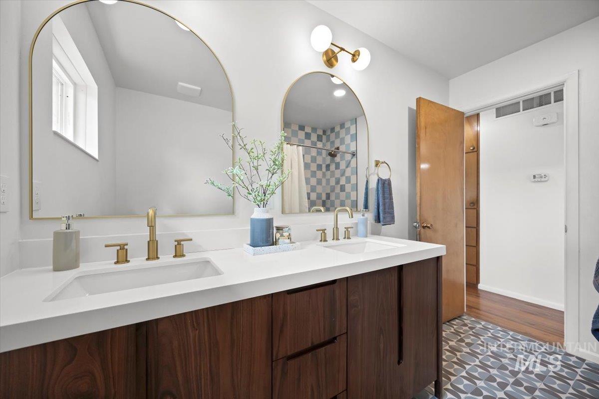 Full bath with double vanity and a shower with curtain