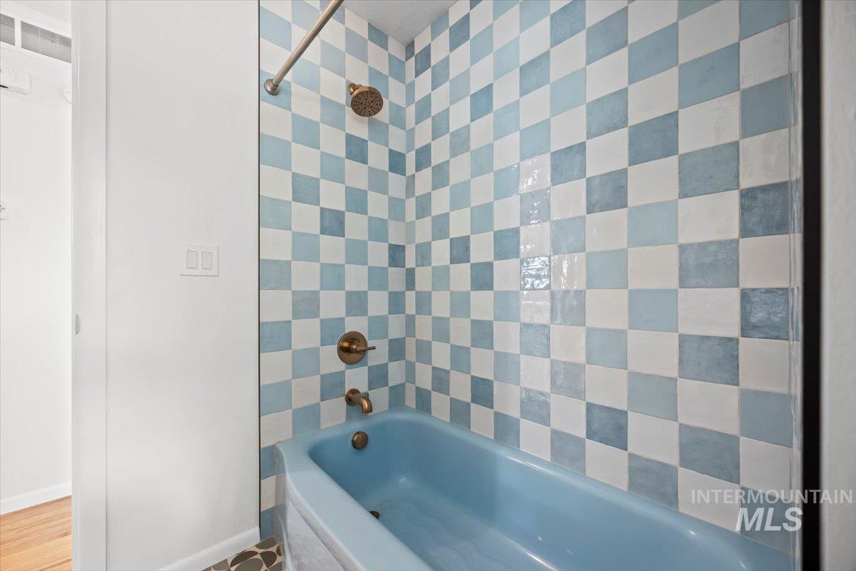 Full bath with tub / shower combination and baseboards
