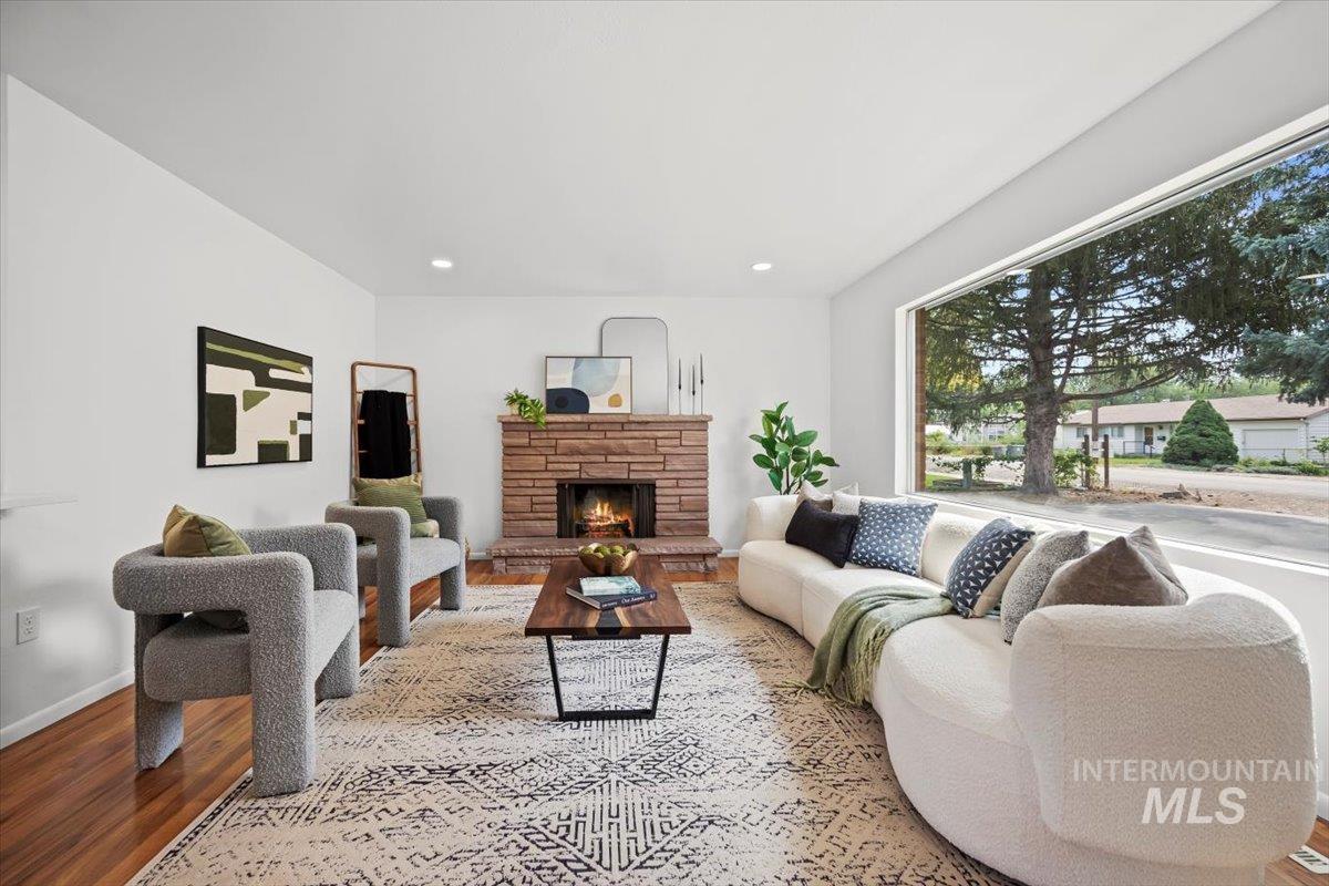 Living room featuring wood finished floors, a fireplace, and recessed lighting