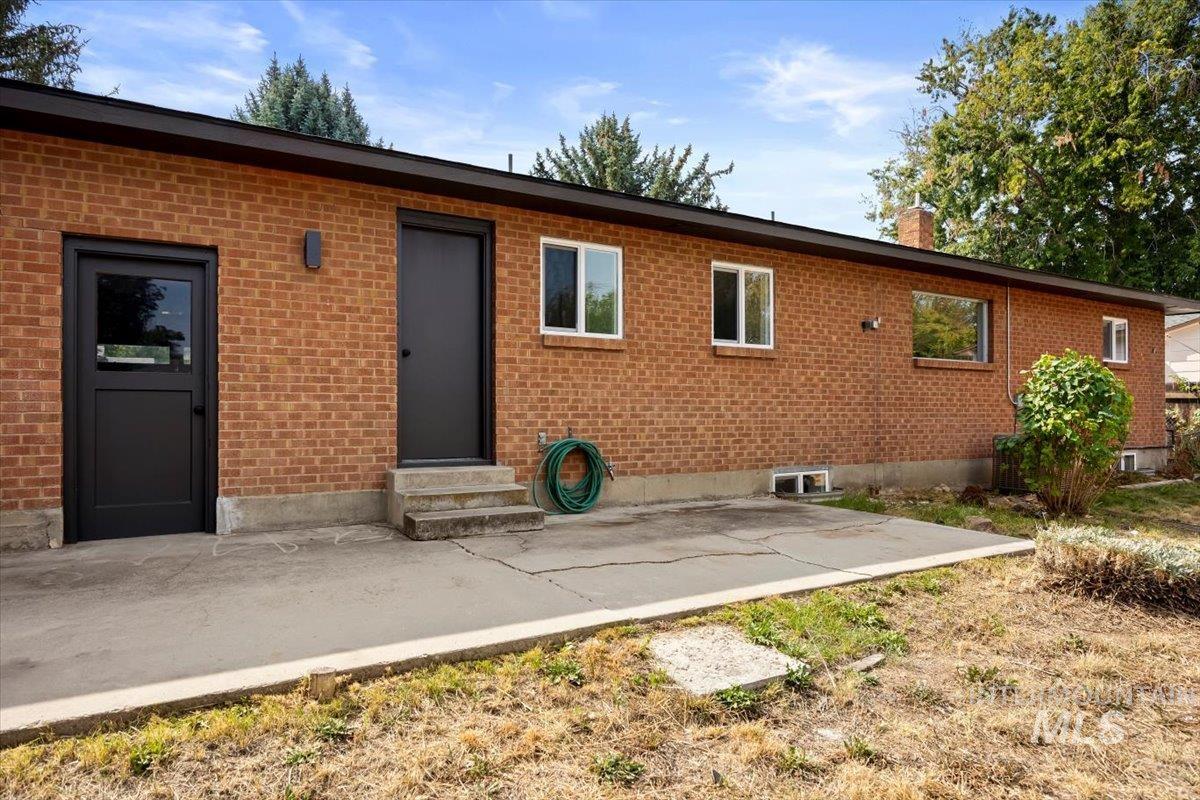 Back of house featuring a patio, brick siding, and entry steps