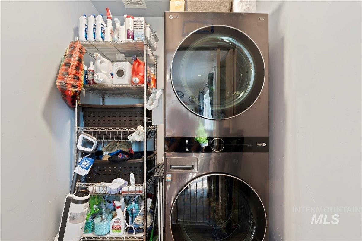 Laundry area featuring stacked washing machine and dryer