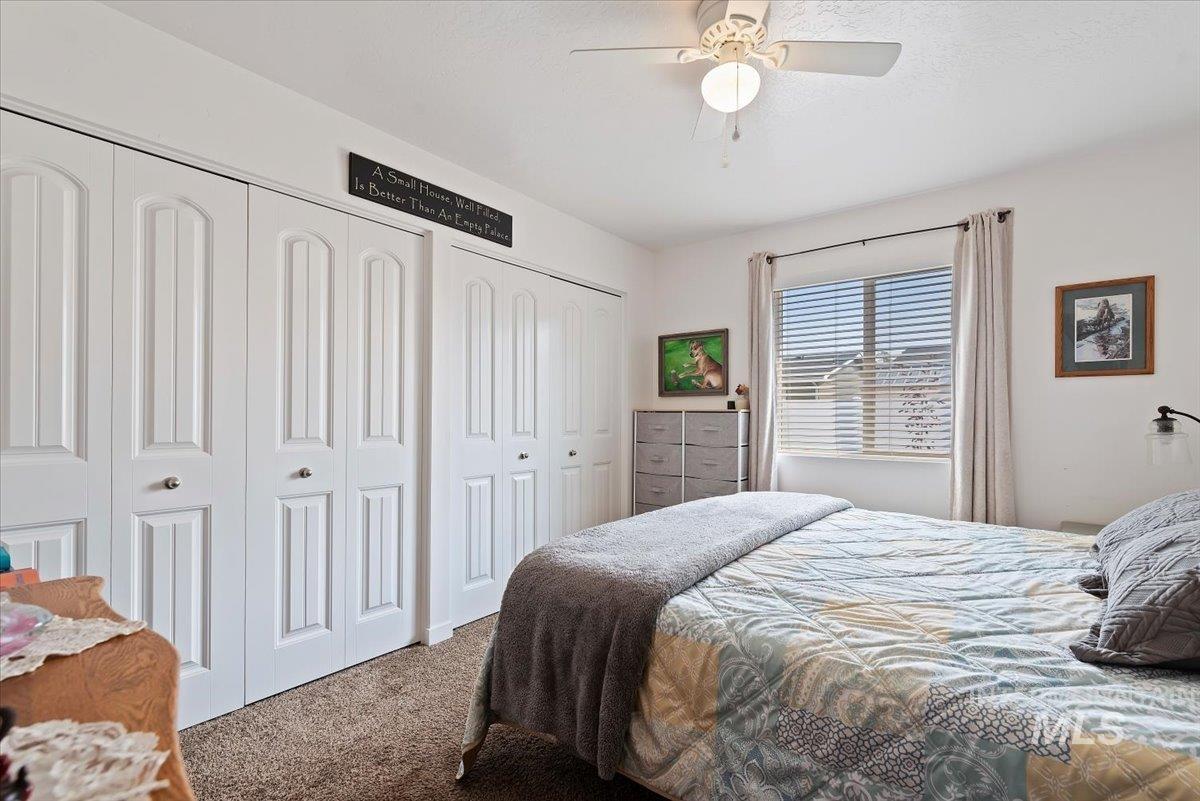 Carpeted bedroom with two closets and a ceiling fan