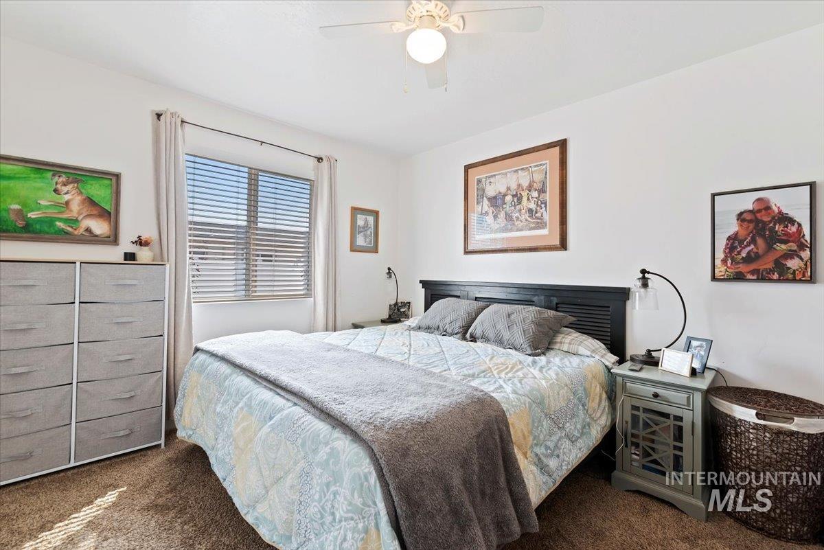Carpeted bedroom featuring ceiling fan