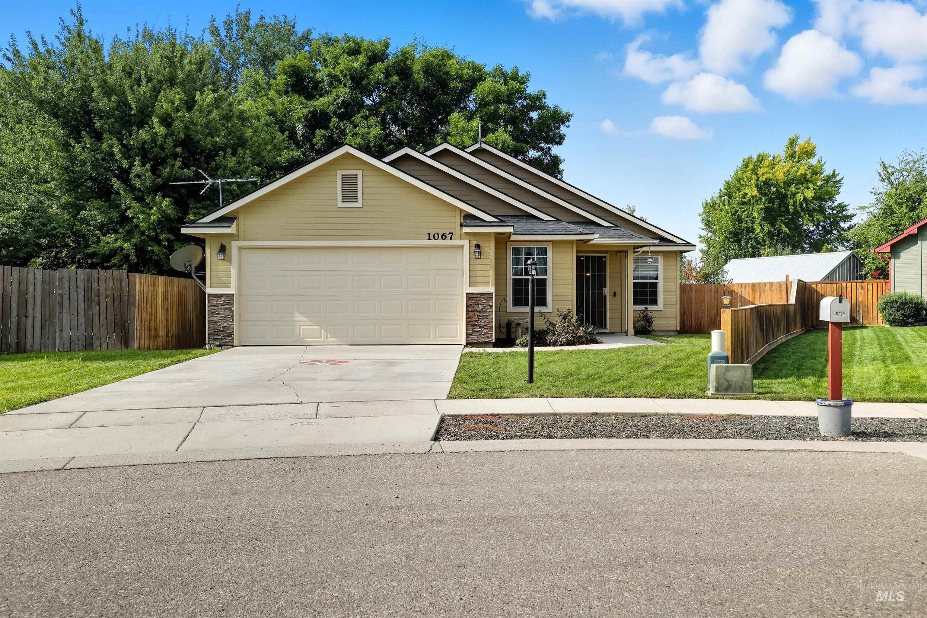 View of front of home featuring stone siding, driveway, and a garage