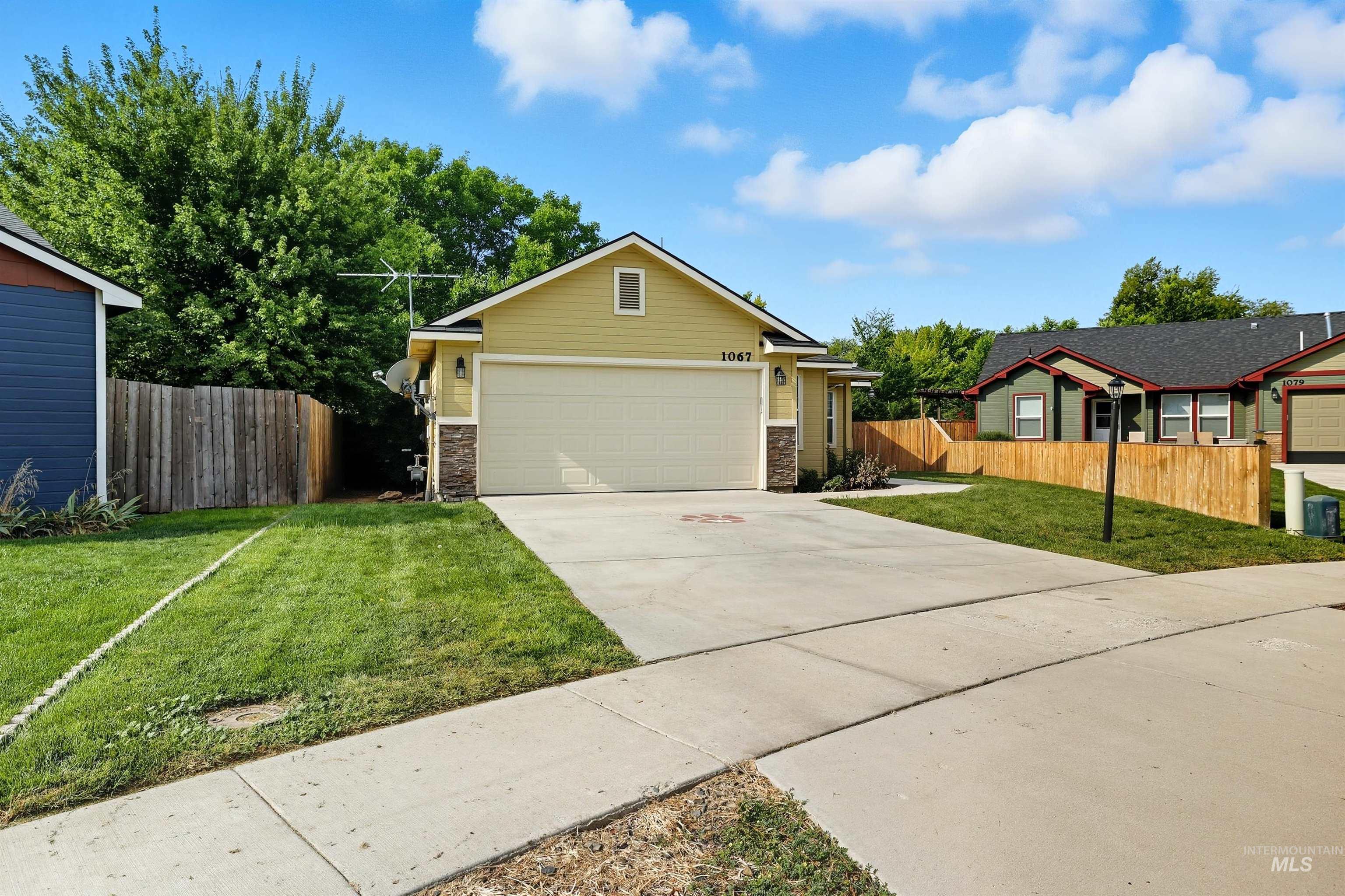 View of front facade featuring concrete driveway, stone siding, and an attached garage
