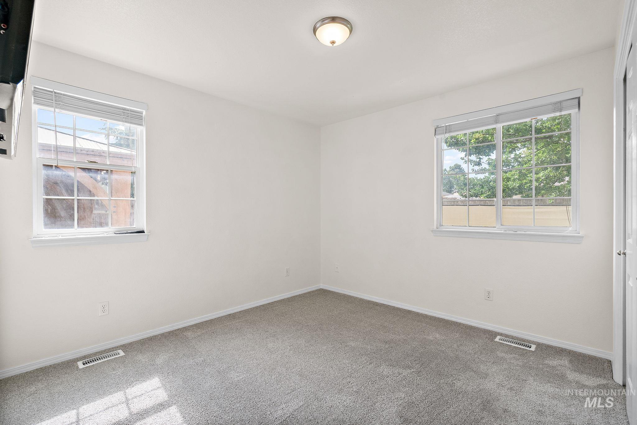 Carpeted spare room with healthy amount of natural light