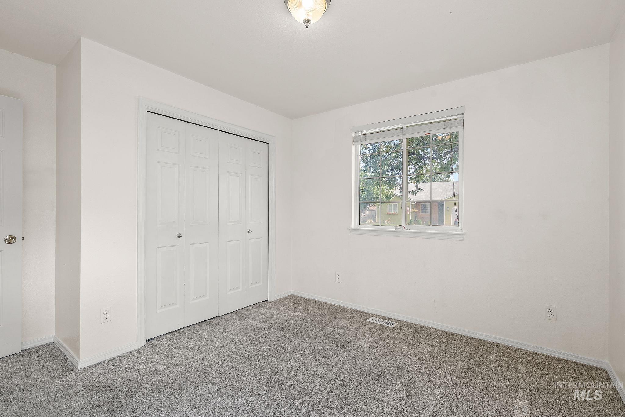 Unfurnished bedroom featuring carpet flooring and a closet