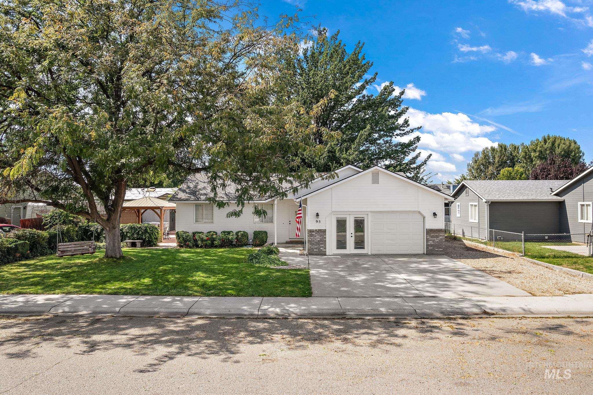 Ranch-style house with concrete driveway, brick siding, and a gazebo