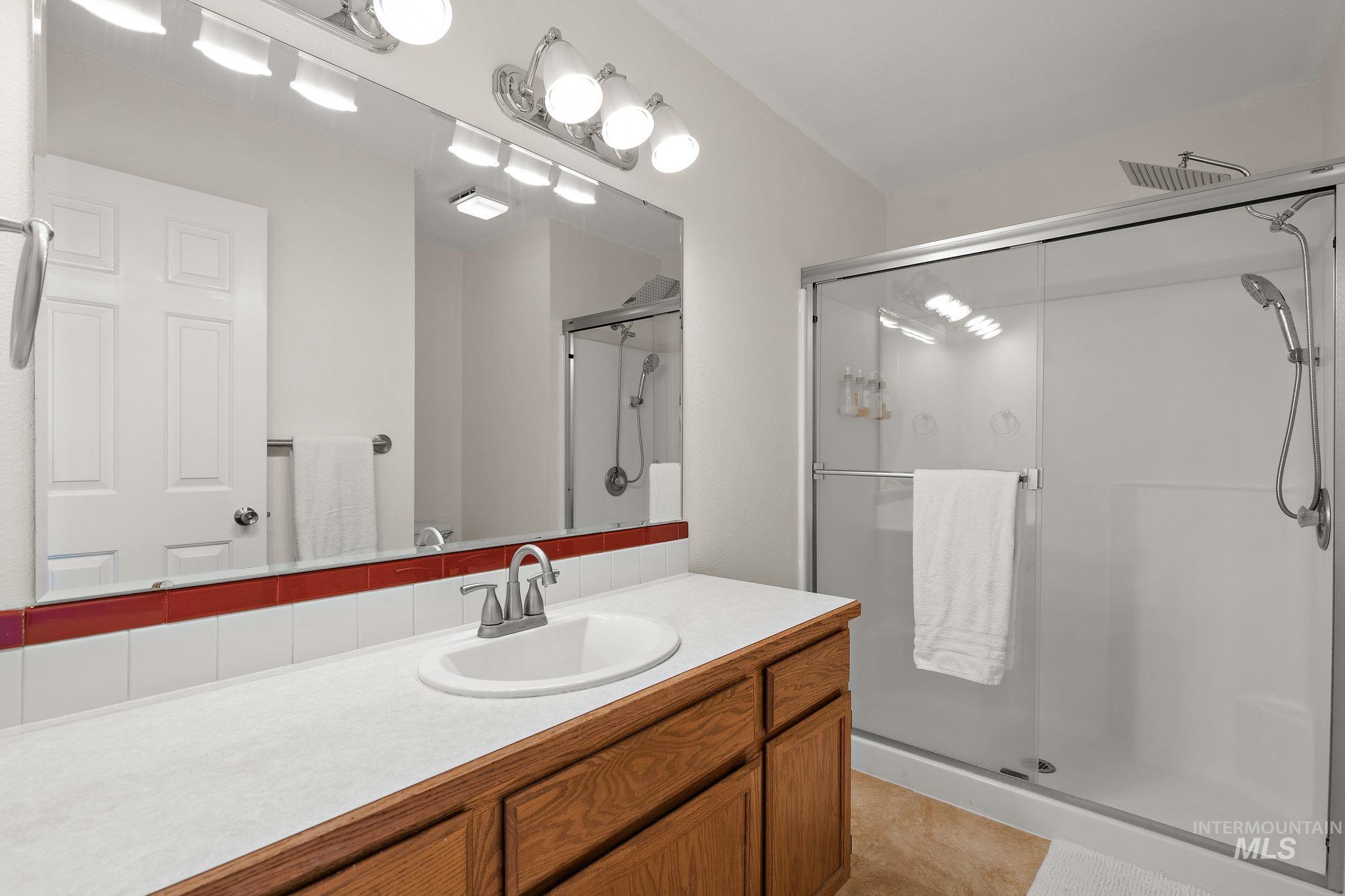 Bathroom featuring vanity, a stall shower, and light tile patterned floors
