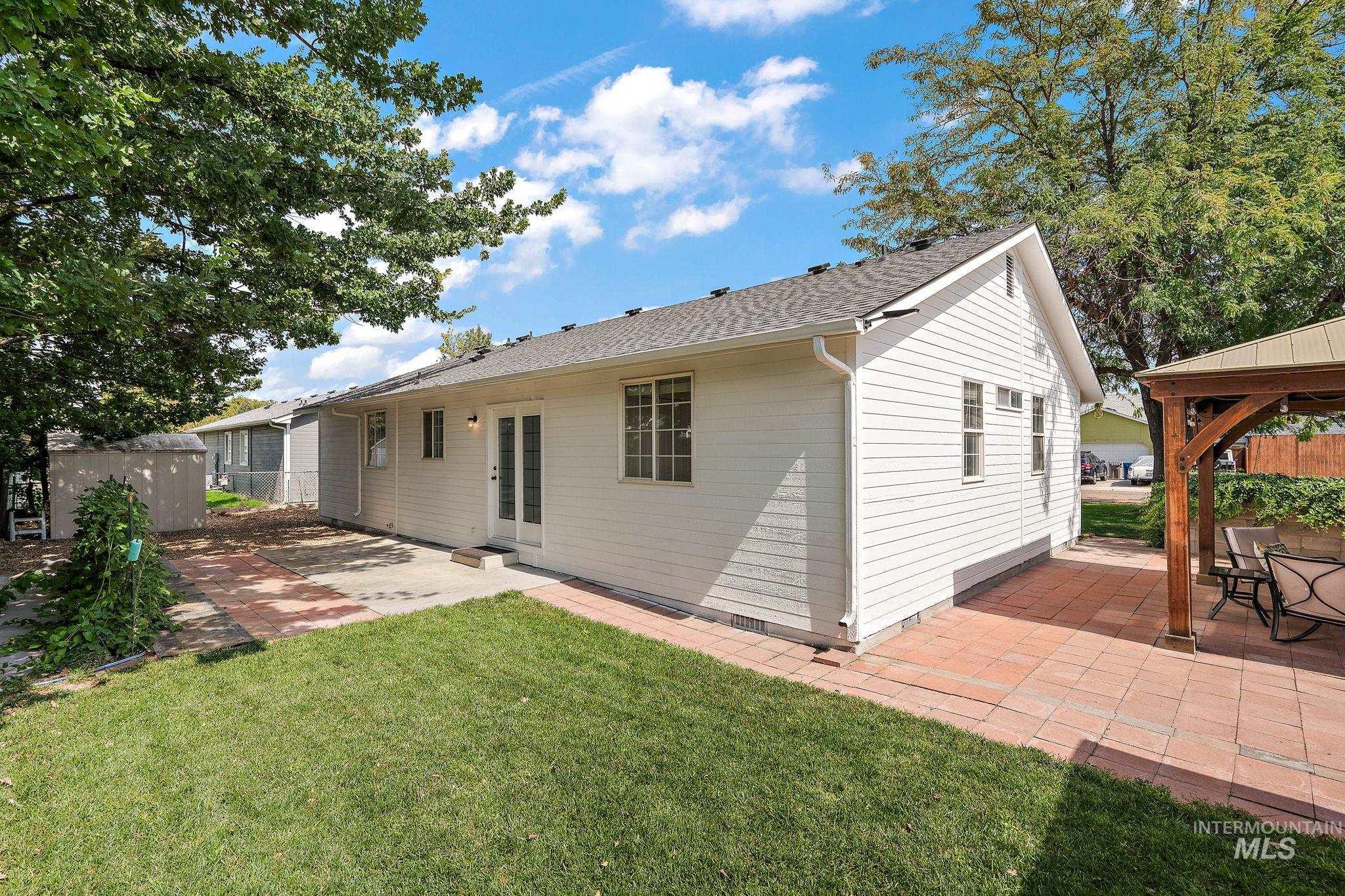 Back of property with a patio area, a gazebo, and roof with shingles