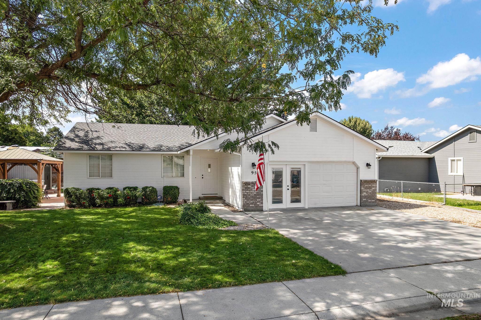Ranch-style home featuring a gazebo, concrete driveway, brick siding, french doors, and an attached garage