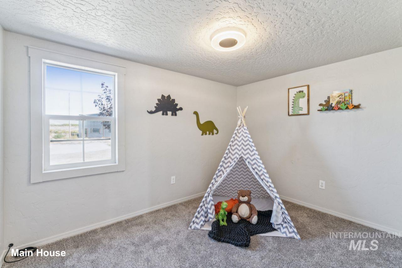 Recreation room with a textured ceiling and carpet flooring