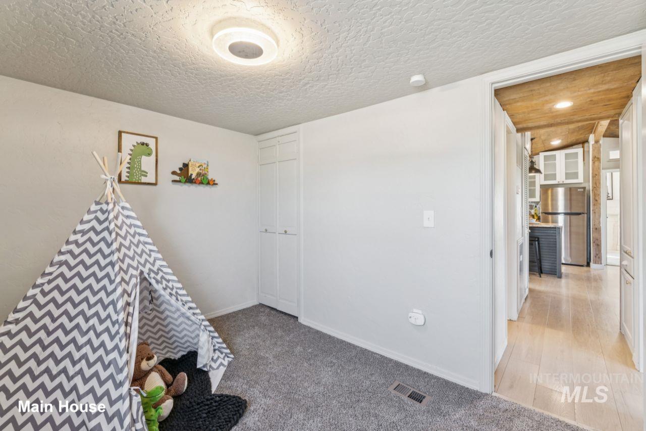 Rec room with a textured ceiling and light colored carpet