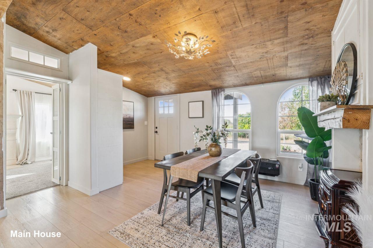 Dining space with lofted ceiling, light wood-type flooring, a chandelier, and wood ceiling