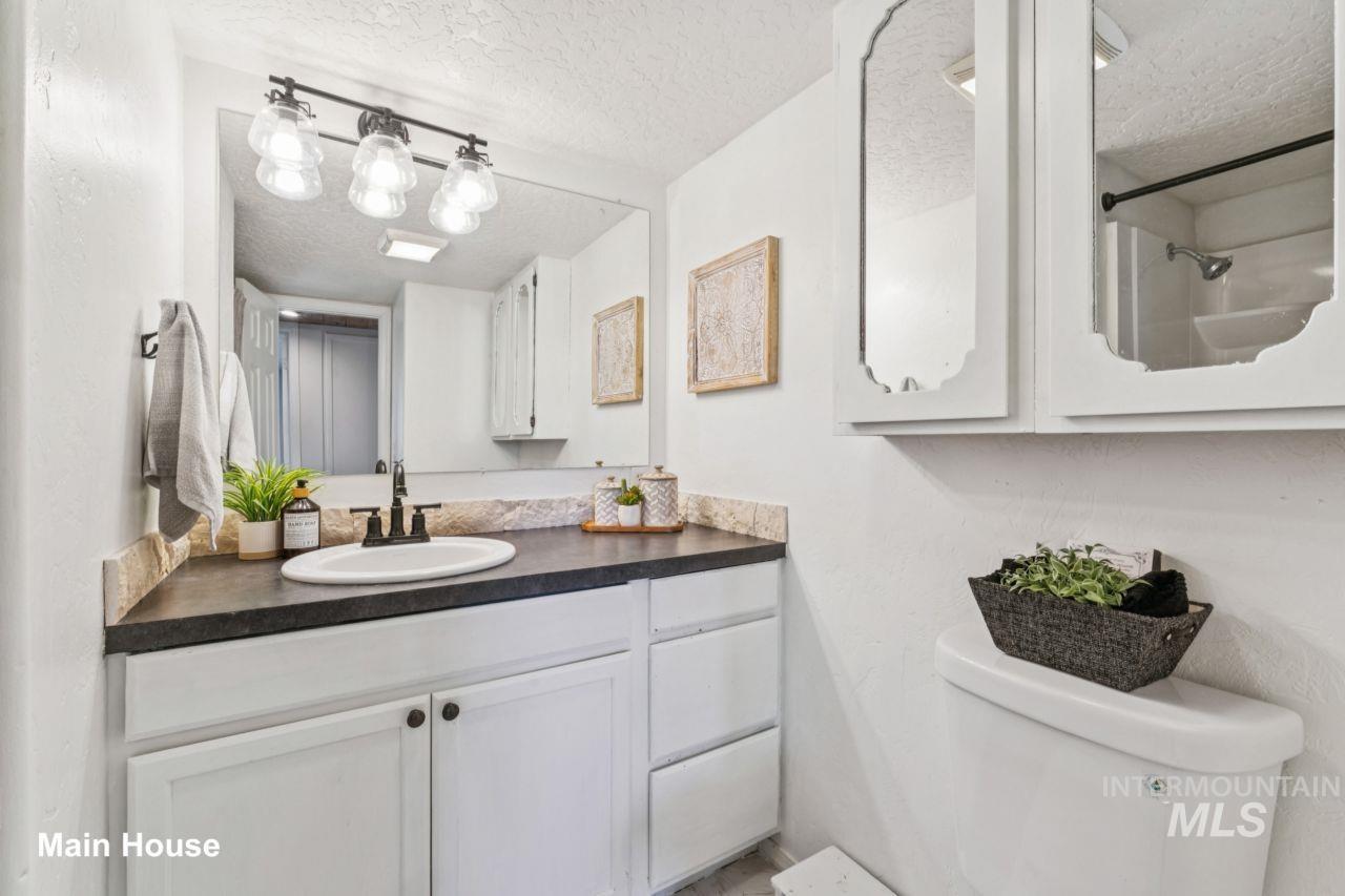 Full bathroom featuring vanity and a textured ceiling