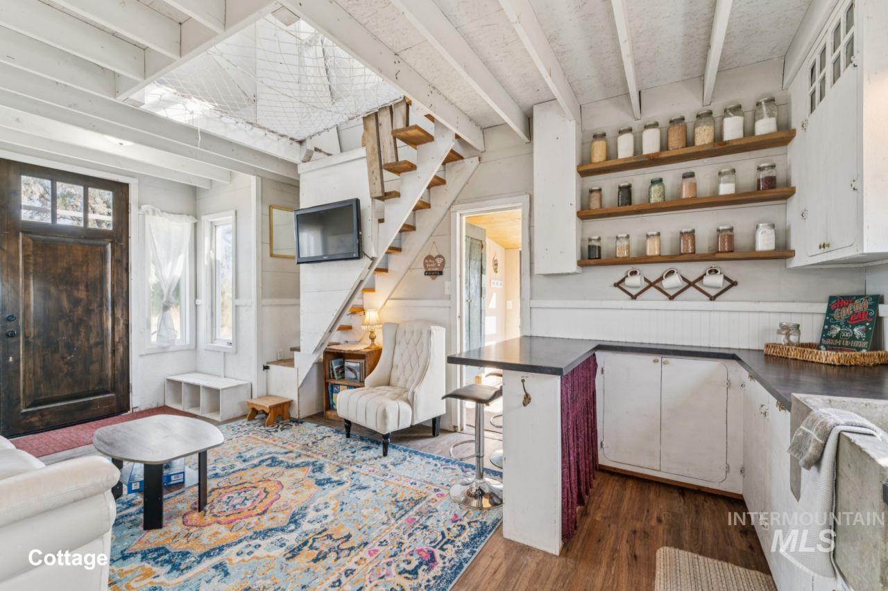 Bar area with beamed ceiling, dark countertops, stairway, open shelves, and dark wood-style flooring