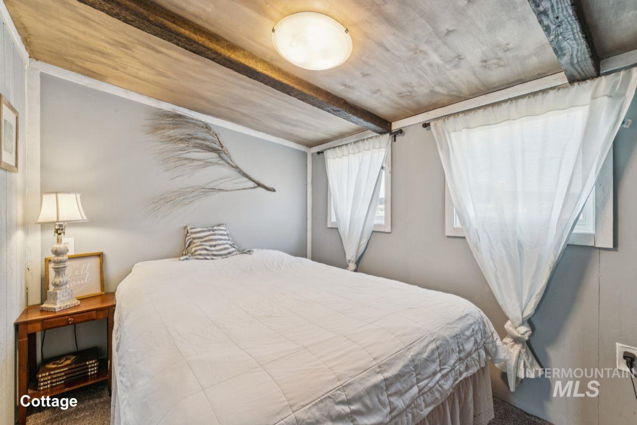 Carpeted bedroom with beamed ceiling
