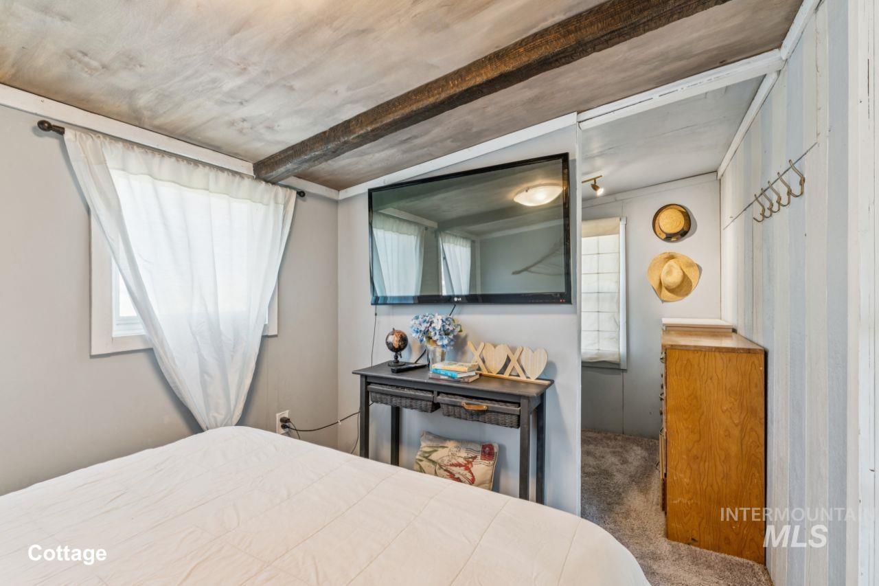 Carpeted bedroom with beamed ceiling