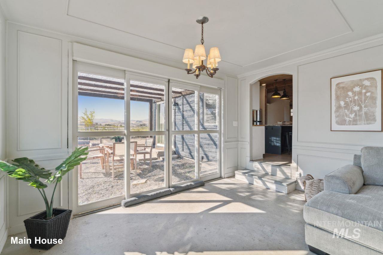 Living area with a decorative wall, arched walkways, a chandelier, and concrete floors