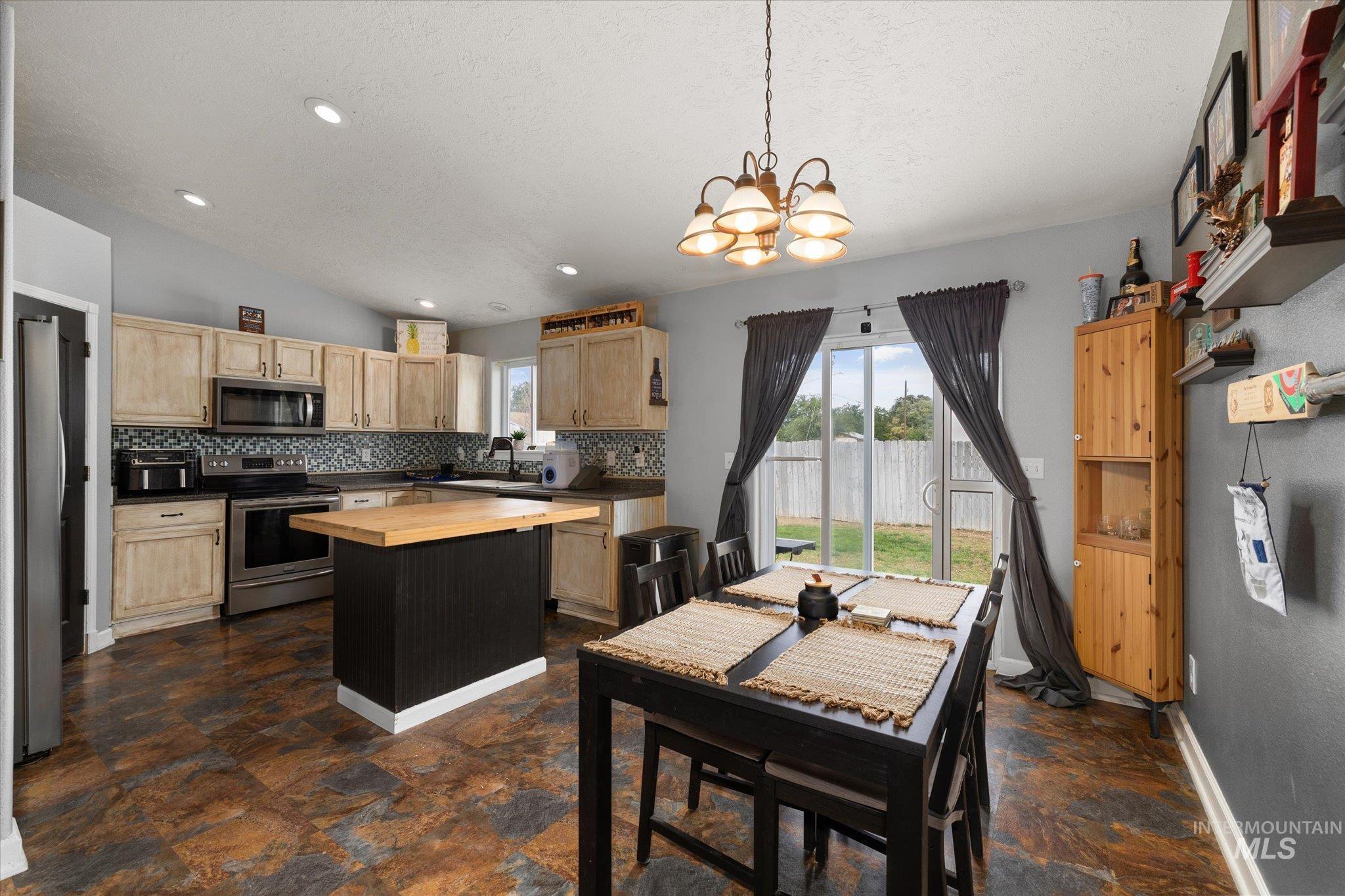 Dining area with recessed lighting, vaulted ceiling, a chandelier, a textured ceiling, and dark stone finish flooring