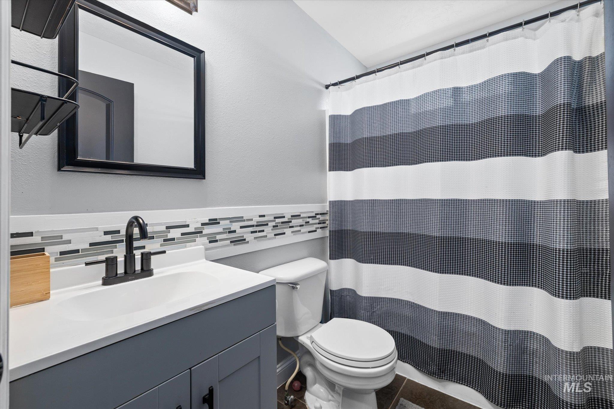 Full bathroom with vanity, tile walls, and a shower with curtain