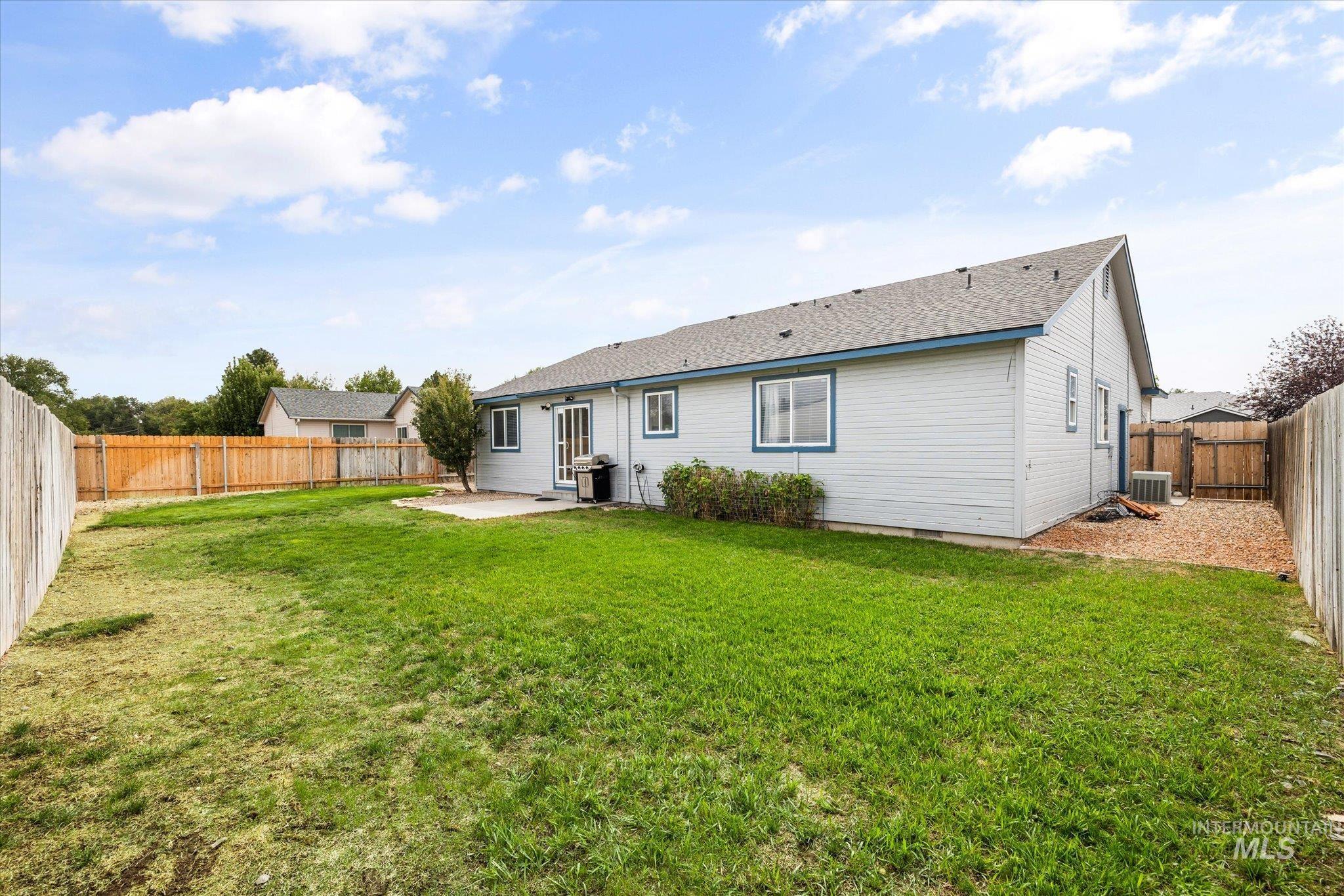 Rear view of property featuring a patio, a fenced backyard, and roof with shingles