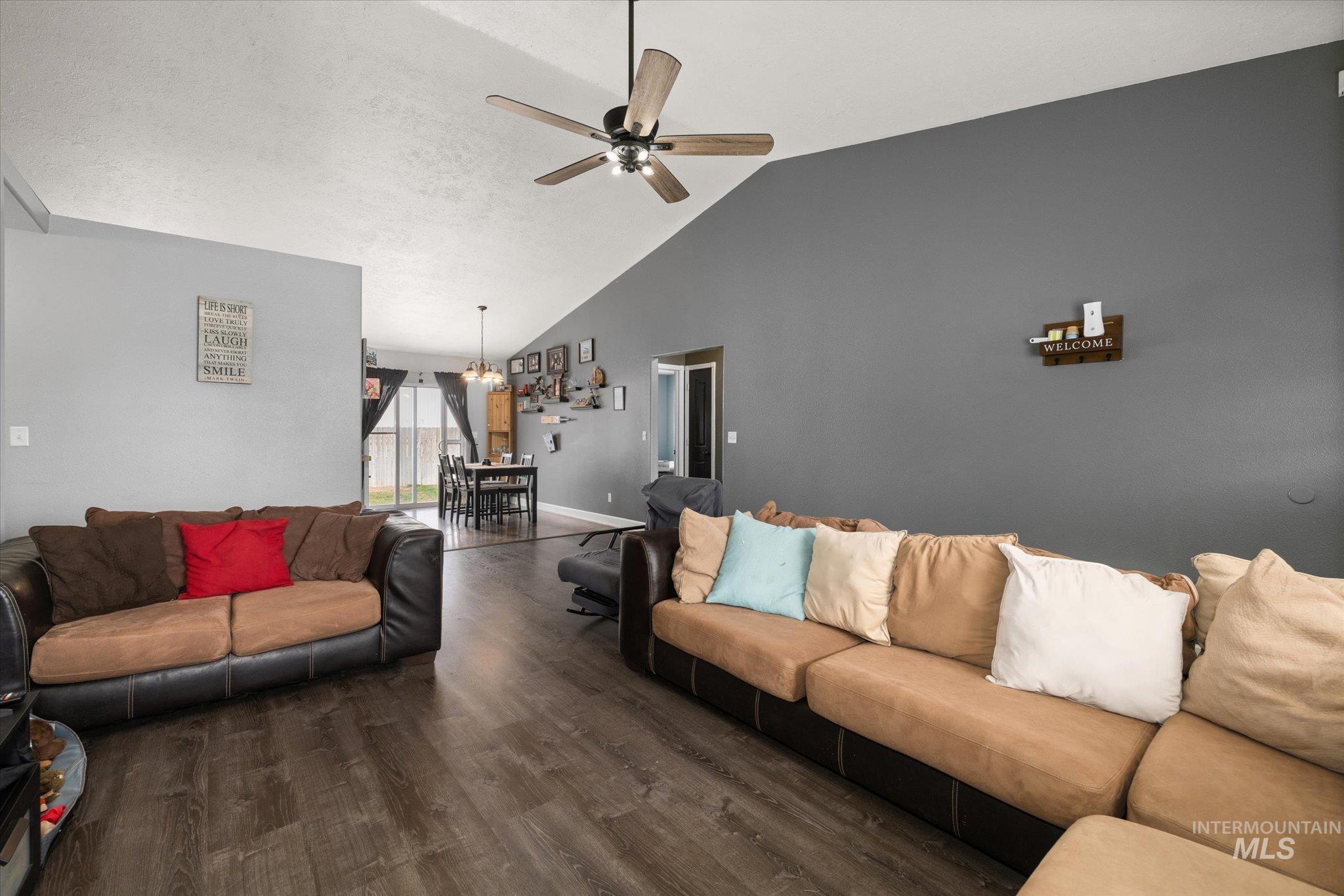 Living area featuring wood finished floors, high vaulted ceiling, and ceiling fan