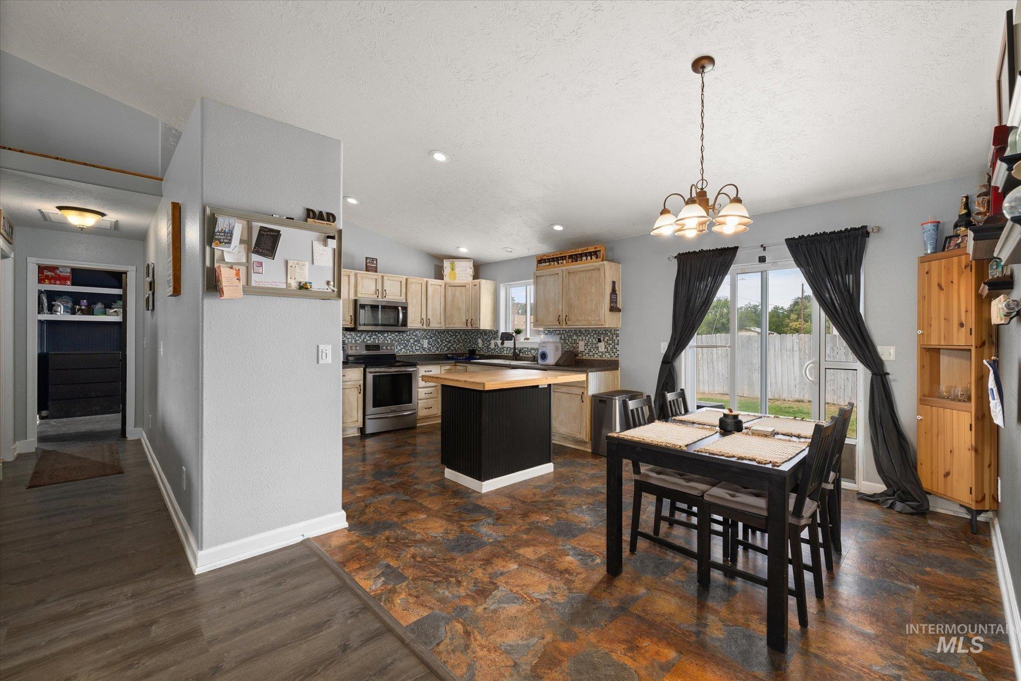 Dining space with vaulted ceiling, recessed lighting, a chandelier, dark wood-style floors, and a textured ceiling