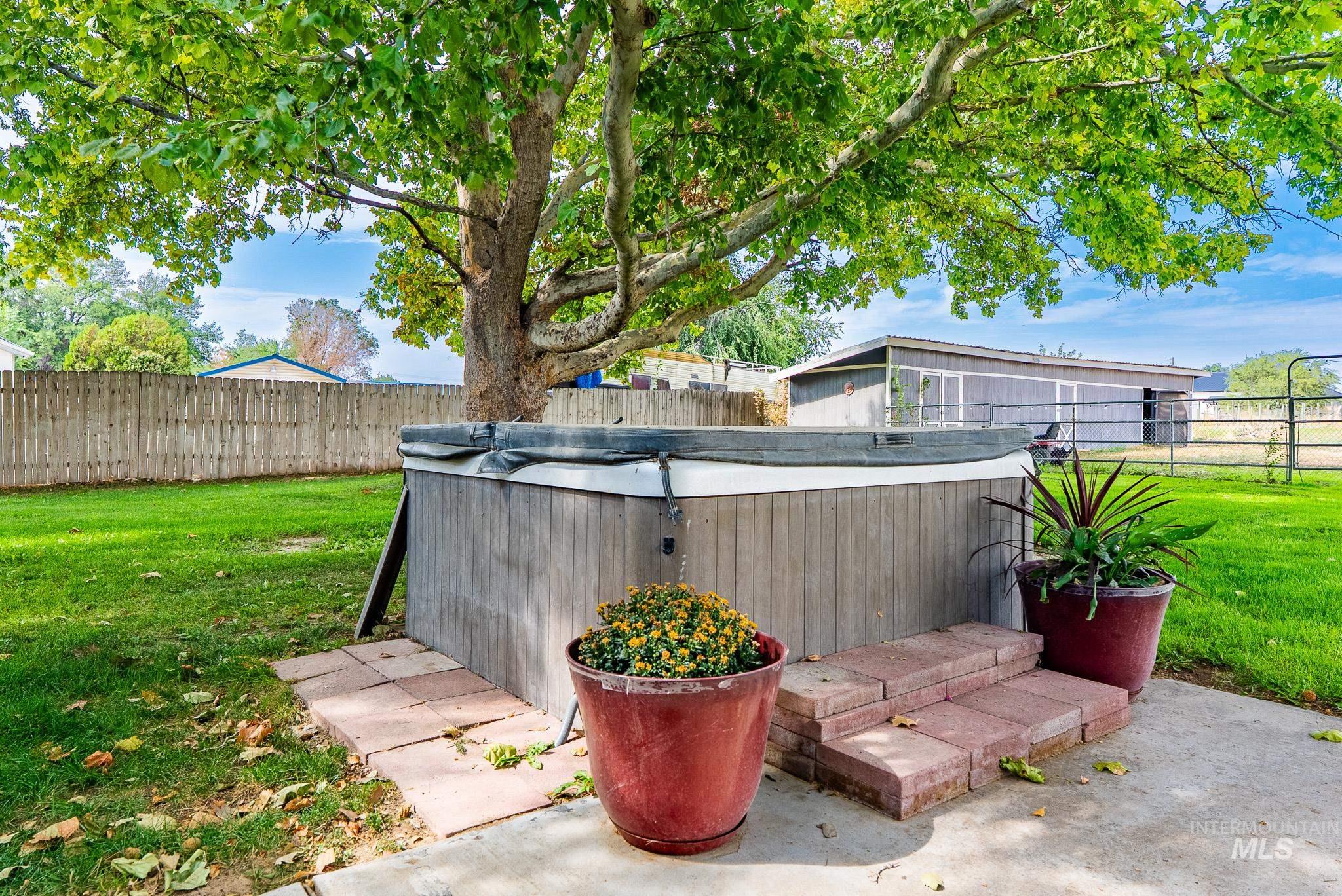 Fenced backyard with a hot tub and a patio