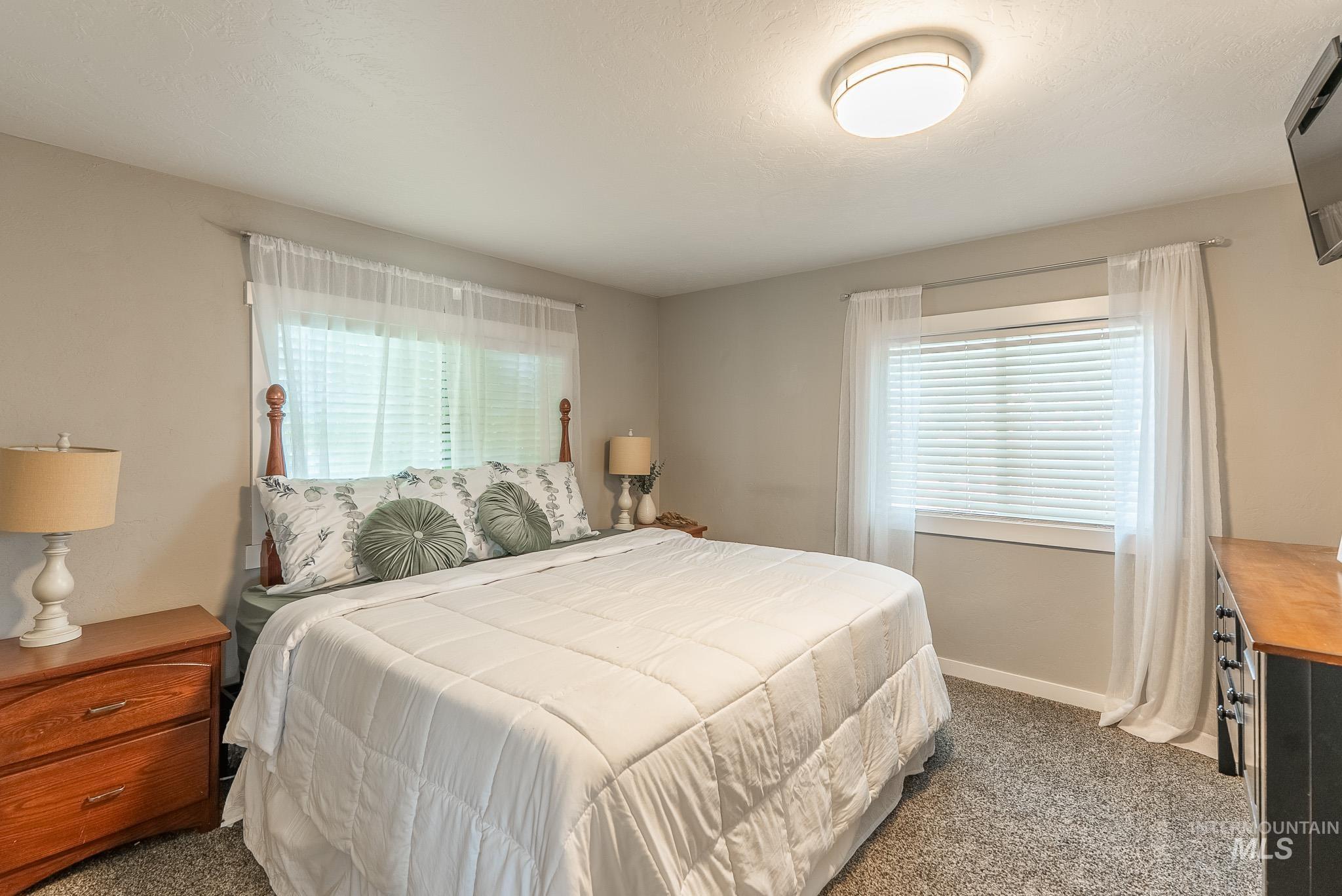 Bedroom with carpet and multiple windows