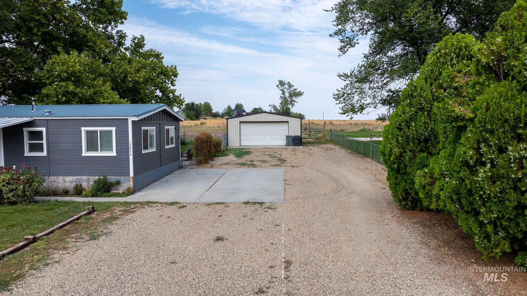 Detached garage featuring dirt driveway