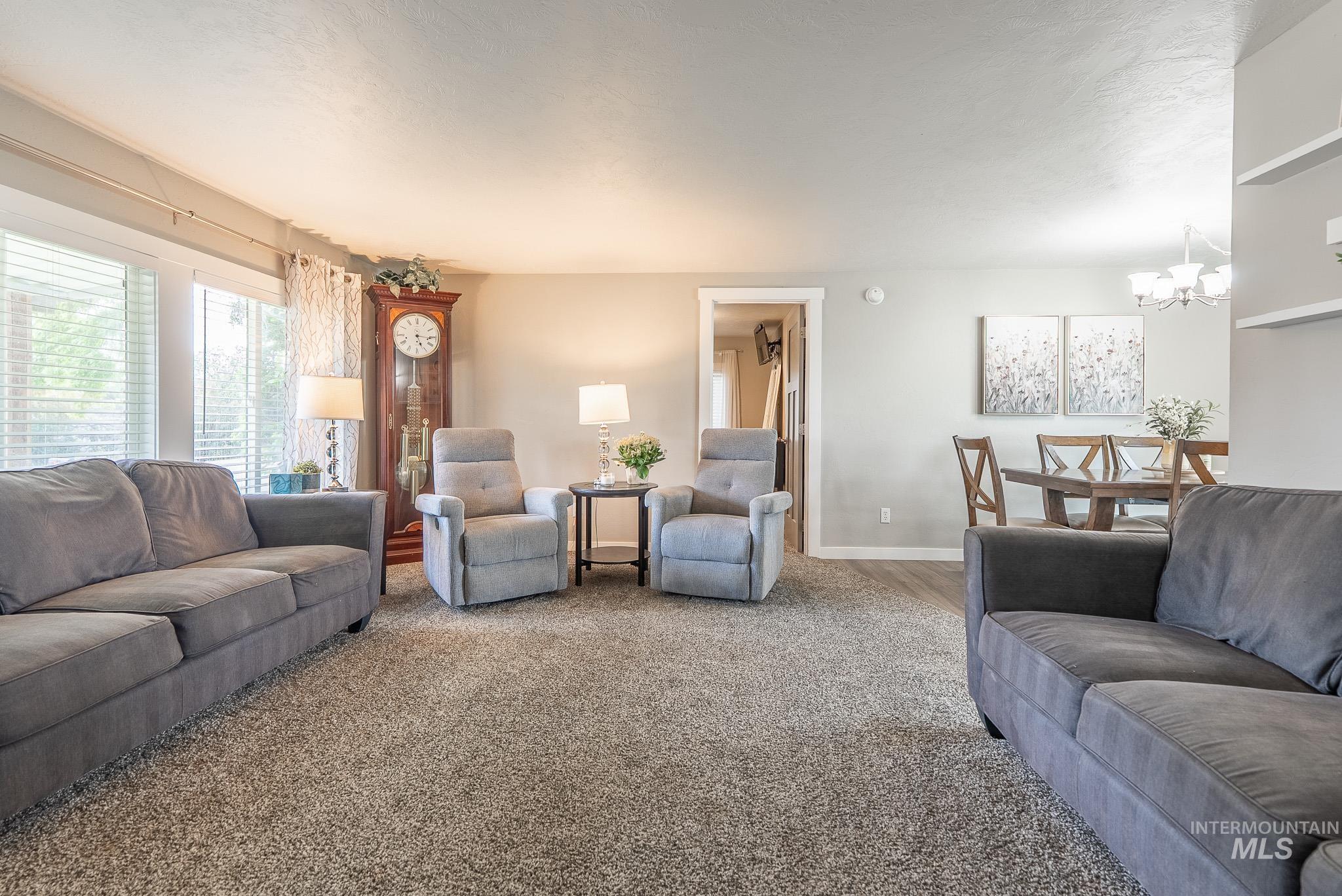 Living area featuring carpet and a chandelier