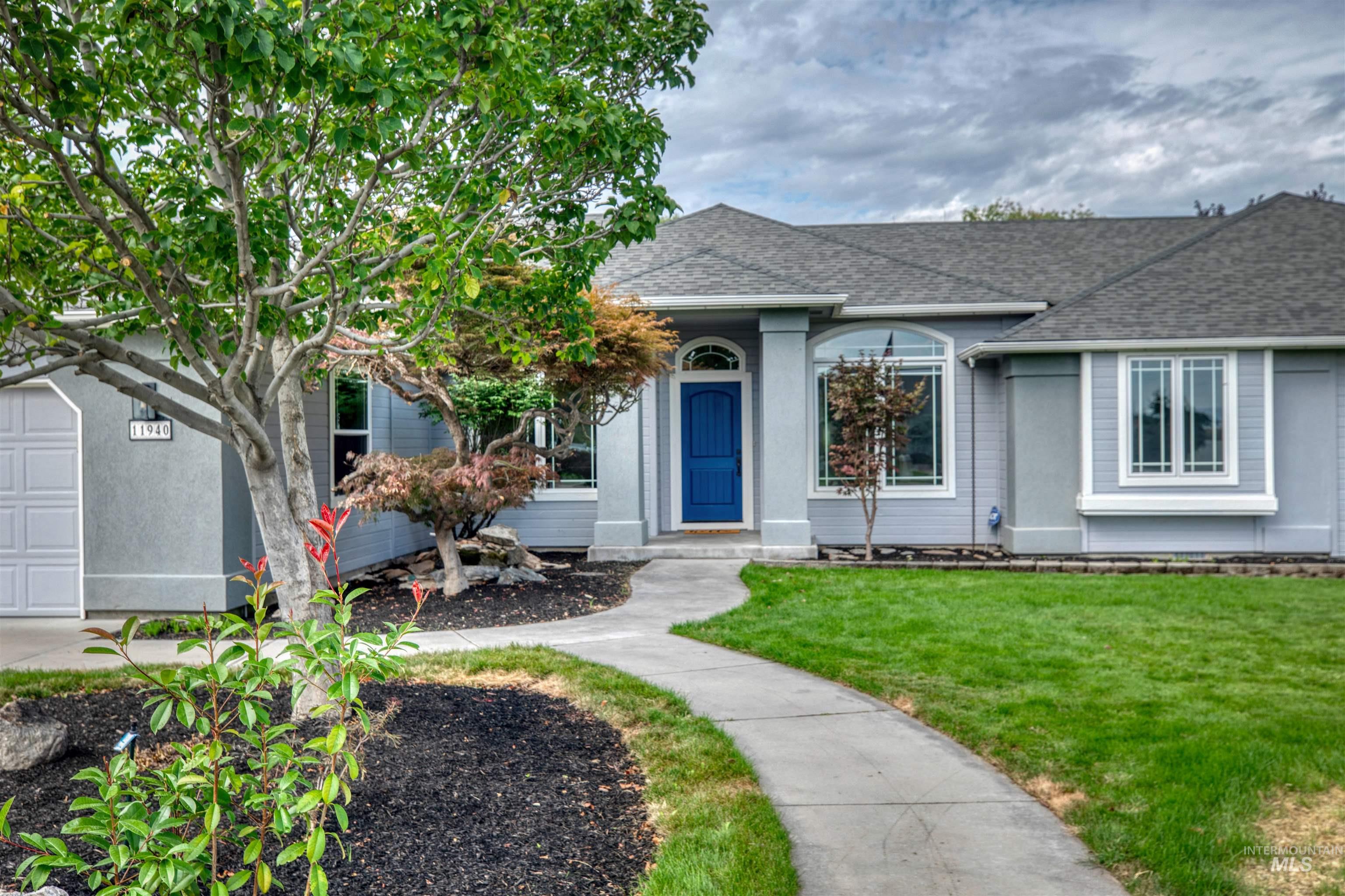 Ranch-style home featuring a shingled roof, a front yard, and a garage