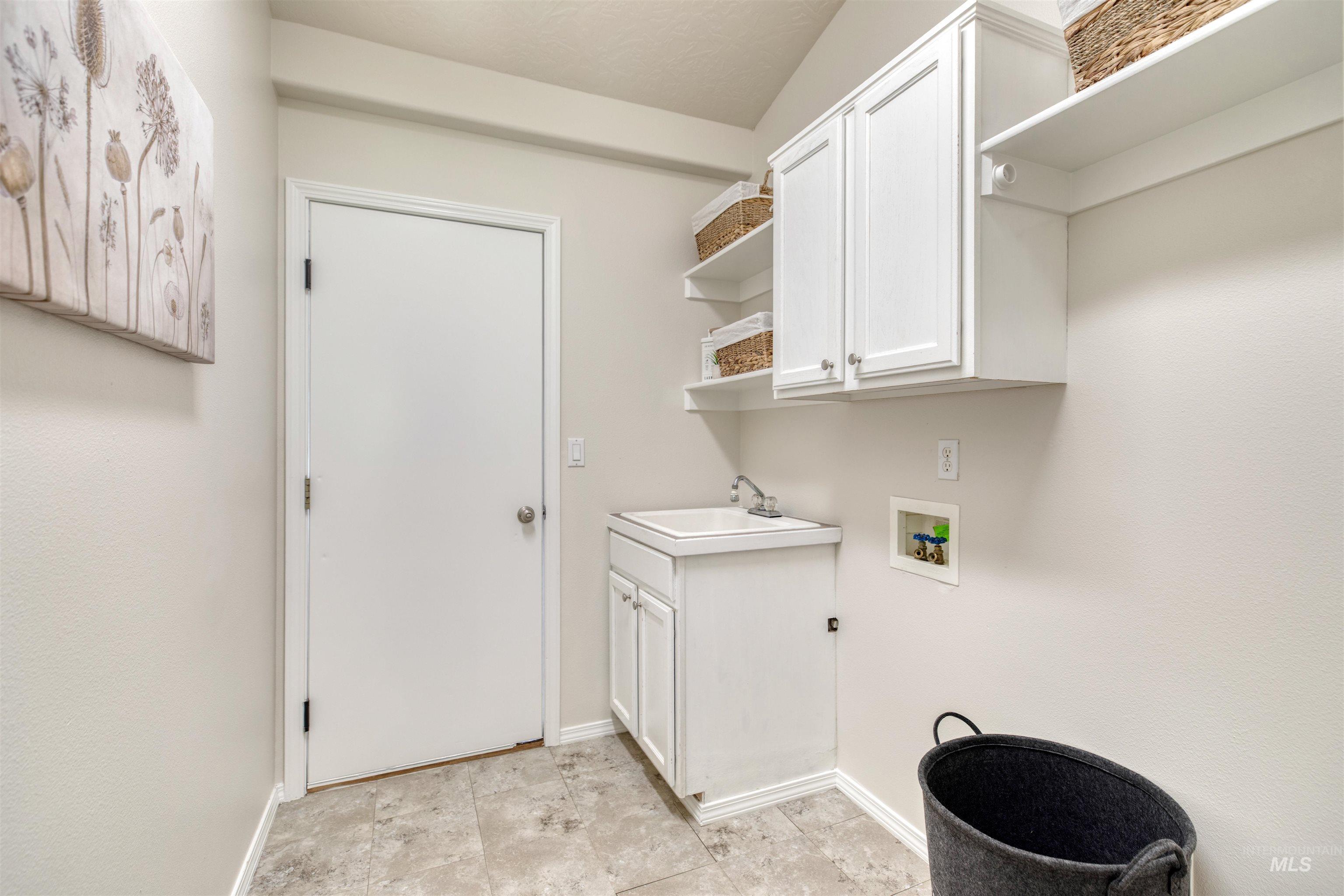 Washroom featuring cabinet space and hookup for a washing machine