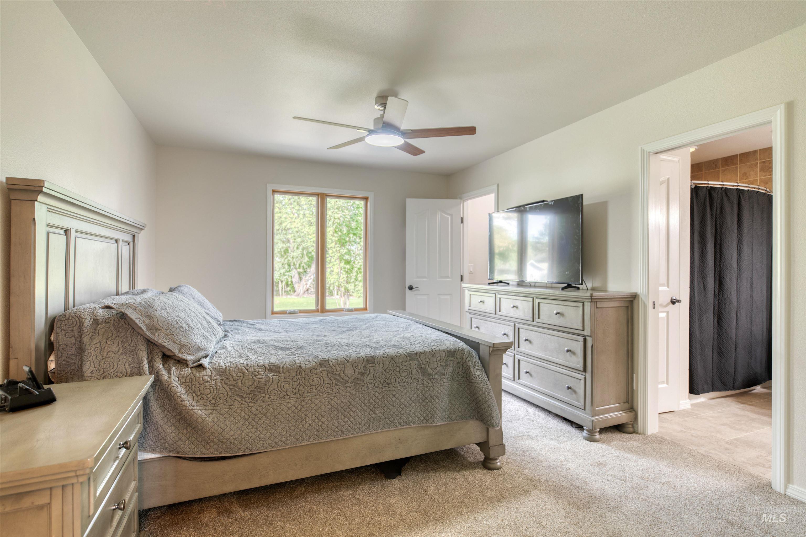 Bedroom featuring light colored carpet and a ceiling fan