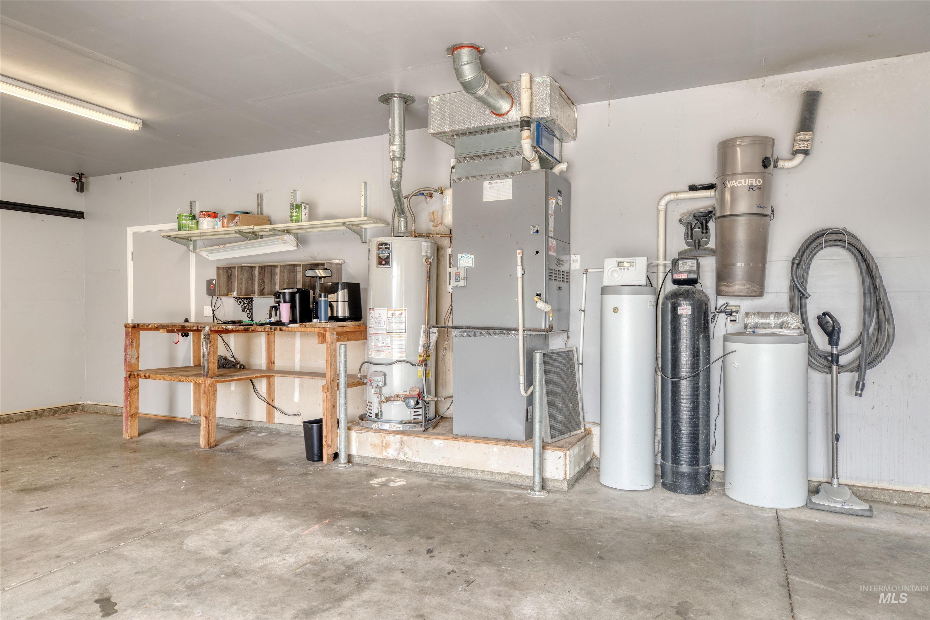 Garage featuring water heater and heating unit