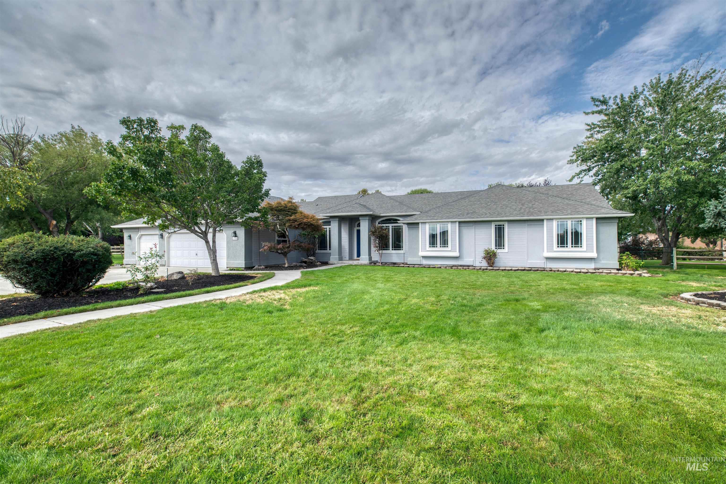 Ranch-style house with a front yard, driveway, and a garage