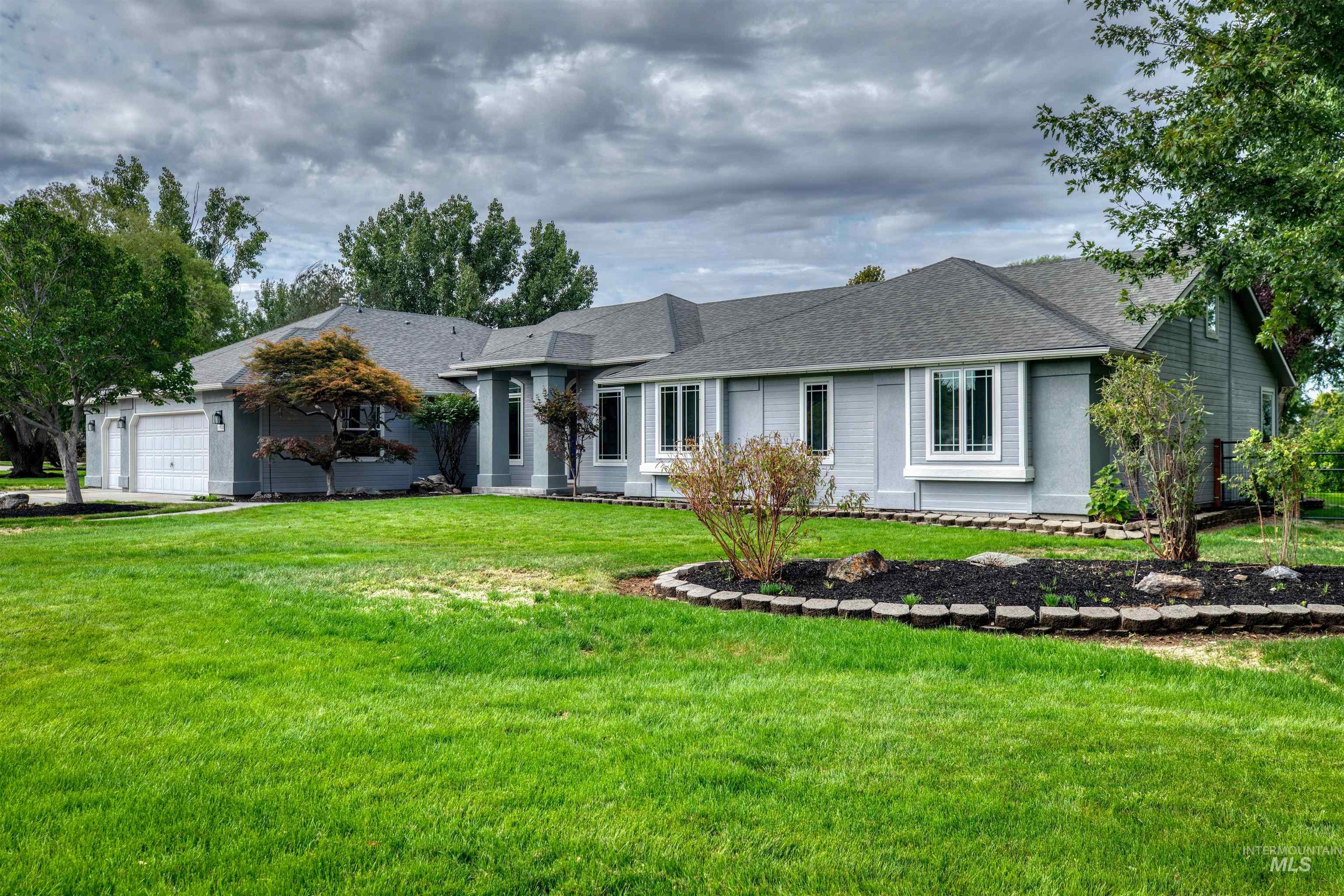 Single story home featuring a front yard, a shingled roof, and a garage