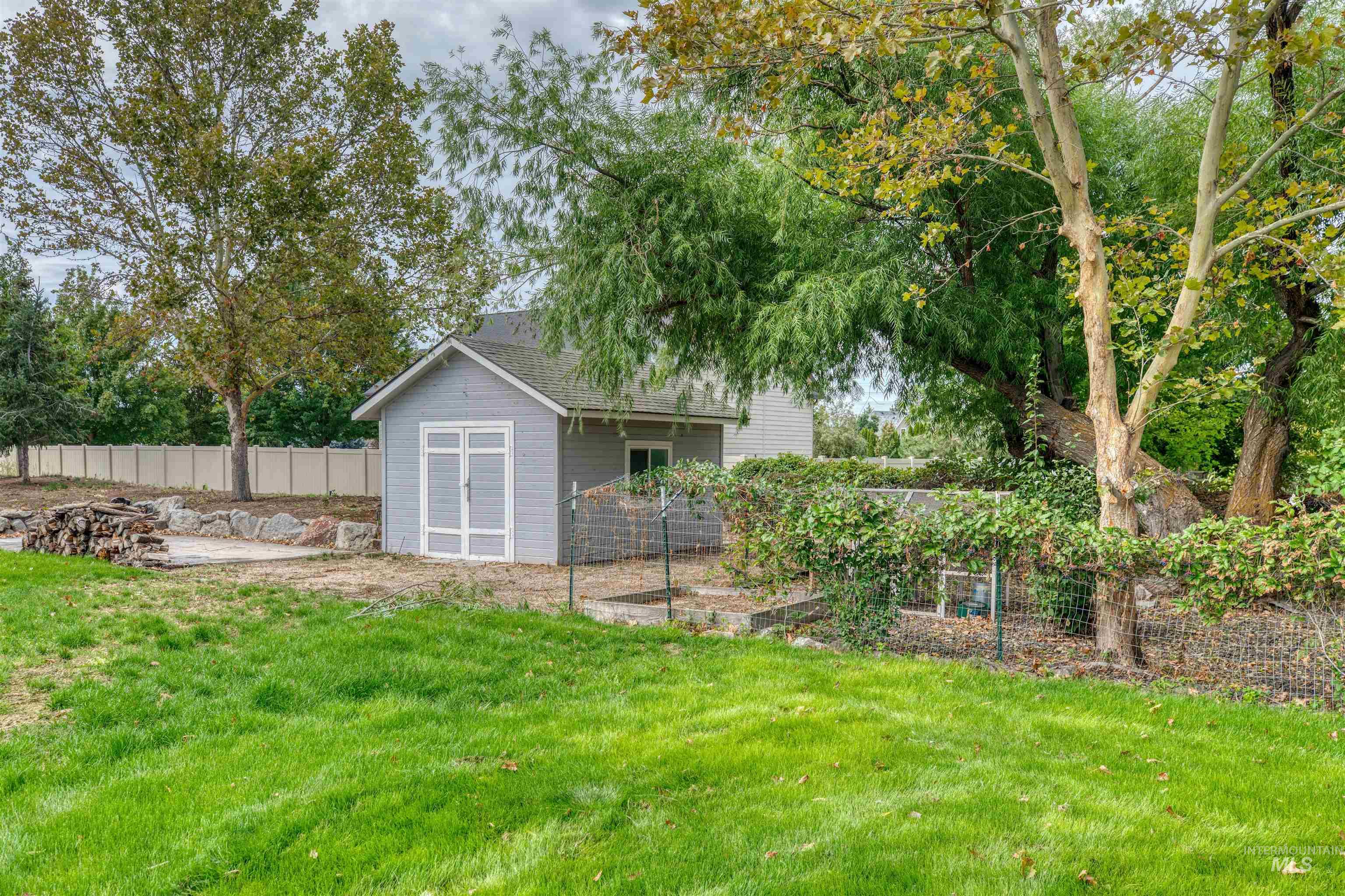 View of yard featuring an outdoor structure, a garden, and view of wooded area