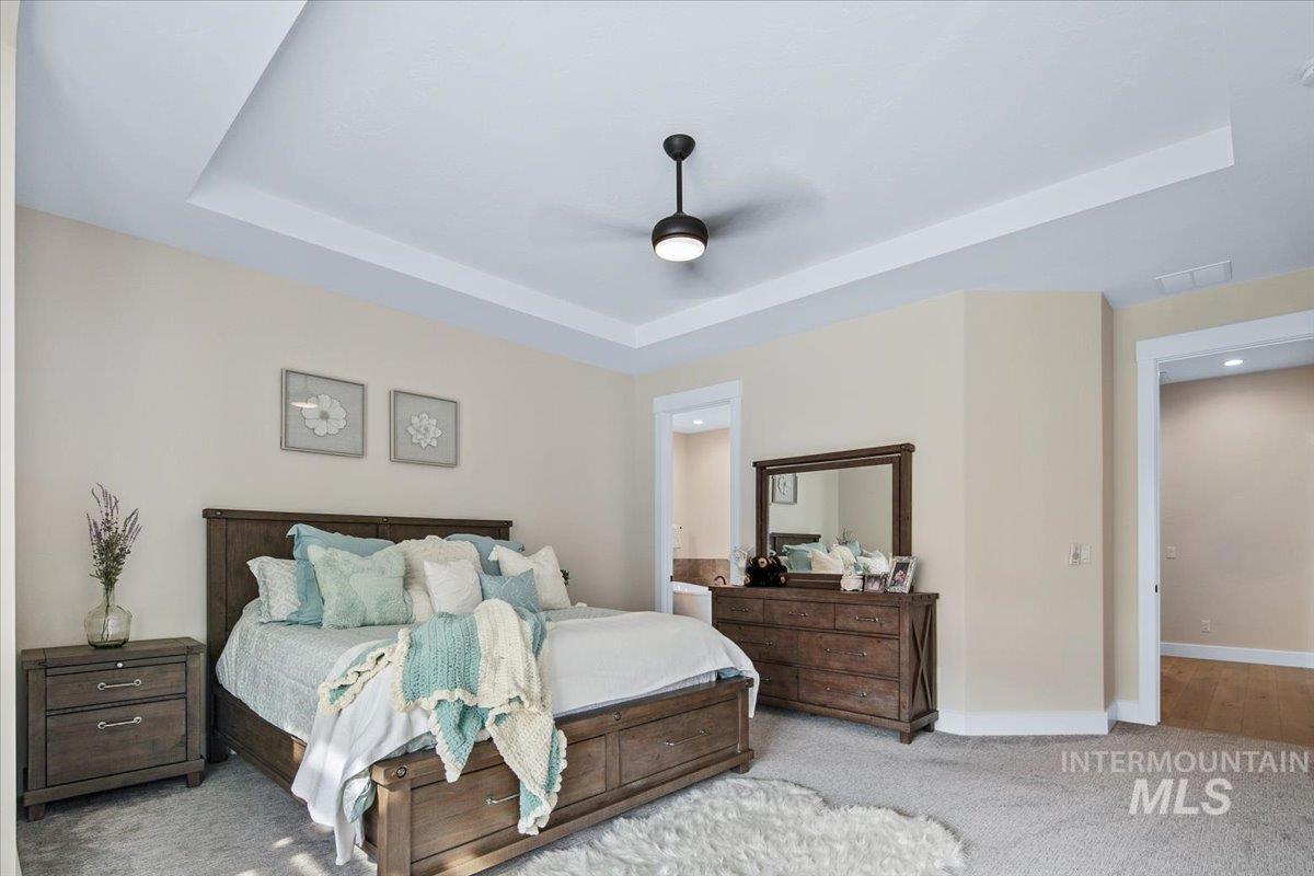 Carpeted bedroom featuring a raised ceiling