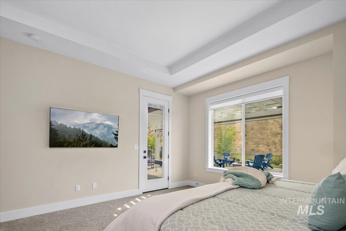 Carpeted bedroom with baseboards and access to exterior