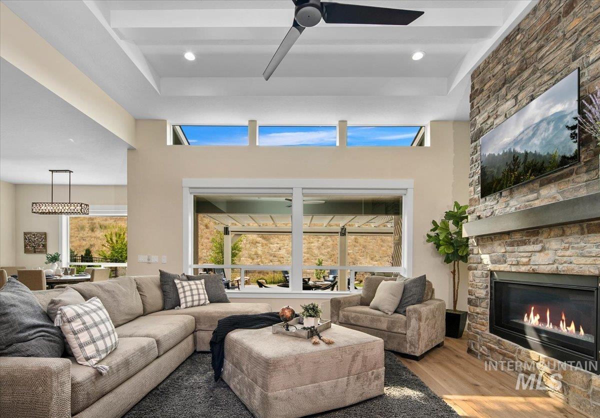 Living area with wood finished floors, a ceiling fan, and a fireplace