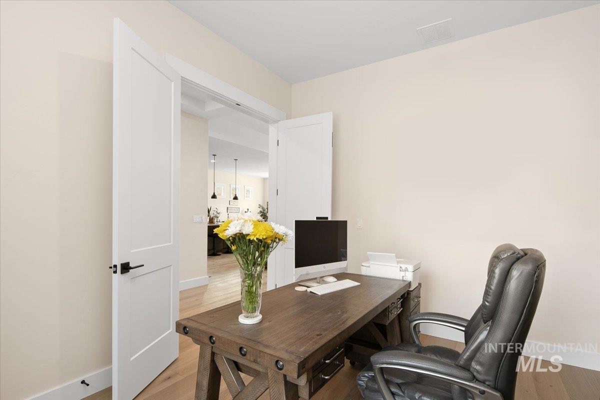 Home office with baseboards and wood finished floors