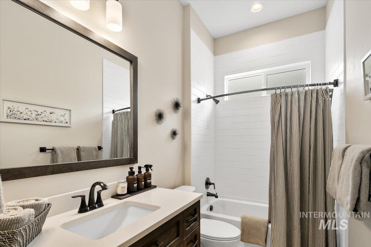 Bathroom with shower / bath combination with curtain and vanity