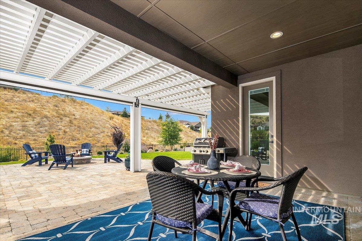 View of patio / terrace with an outdoor fire pit, a pergola, outdoor dining space, and a mountain view